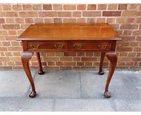 A MAHOGANY SIDE TABLE fitted with two drawers, on carved claw and ball cabriole supports, 92cm wide, 50cm deep, 71cm high