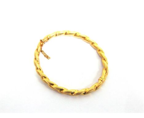 A 9 CARAT GOLD HINGED BANGLE of barley twist design, 6cm internal diameter, 10.8g gross