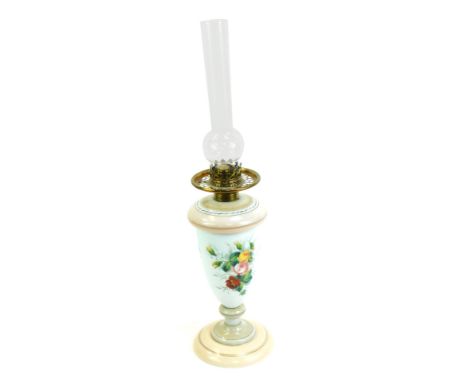 A Victorian milk glass oil lamp, with glass chimney, the base decorated with flowers against an opaque white ground, blush pi