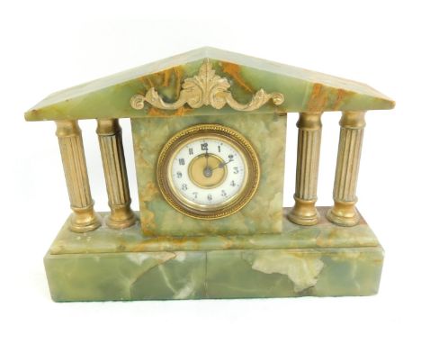 An early 20thC onyx mantel clock, the brass dial with white enamel chapter ring bearing Arabic numerals, key wind, the case o