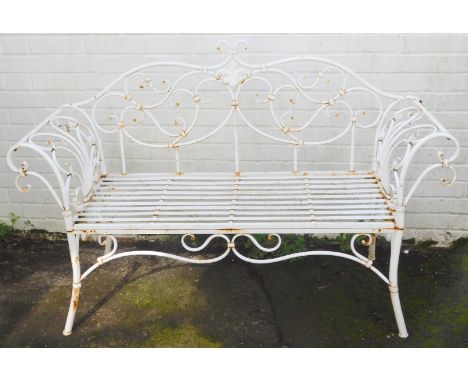 A 20thC wrought metal two seater garden bench, in white, with scroll motifs and slatted base, 142cm wide. 