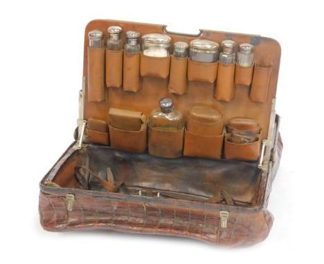 A Victorian crocodile skin Gladstone type travel case, with a two section interior, containing leather, and cut glass and sil