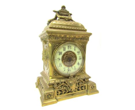 A late 19thC French brass cased mantel clock, the circular cream enamel dial bearing Arabic numerals, the case of ornate desi