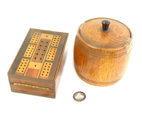 An early 20thC oak tea caddy, 14cm high, and a boxwood draughts board, 13cm wide, together with a Holiday Camp Douglas pin. (