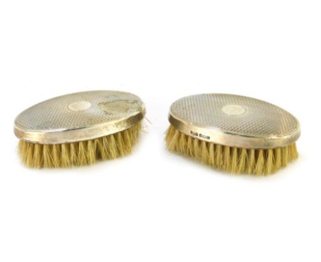 A pair of Edward VI silver backed hair brushes, with engine turned decoration, circular vacant reserve, Birmingham 1902.