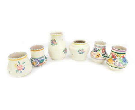 A group of Poole pottery, traditionally decorated with floral sprays, comprising six vases of differing form and design, the 