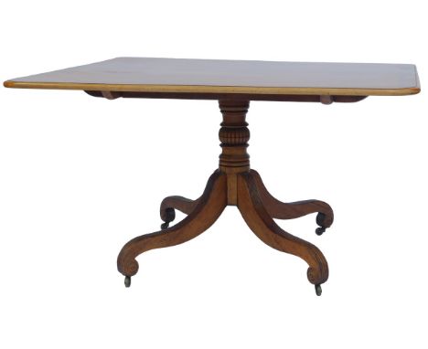 A mahogany and rosewood cross banded dining table, the rectangular top with a rounded edge, on a turned pedestal, on fluted s