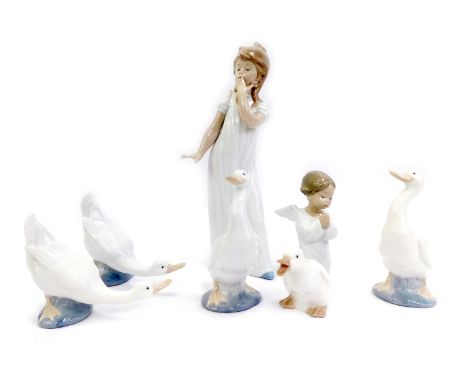 A group of Lladro and Nao porcelain, comprising a Lladro porcelain figure of a kneeling cherub, 16cm high, a Nao figure of a 