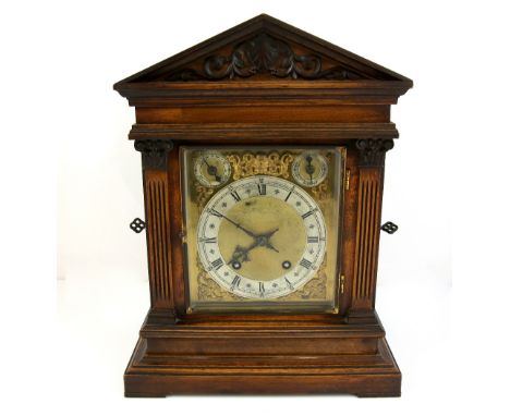 An oak two train mantel clock the silvered dial stamped Goldsmiths and Silversmiths, two subsidiary dials in carved case, 42c