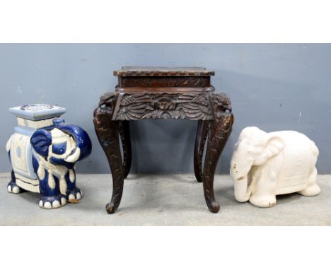 Two ceramic garden seats each in the form of elephants and a carved occasional table. (3).   