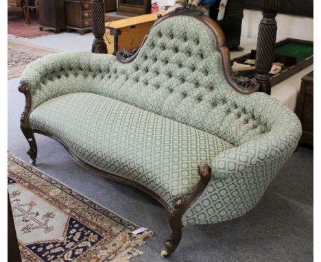 A Victorian Mahogany Framed Button Back Sofa, the shaped back above inwardly curved arms over a serpentine seat, raised on ca