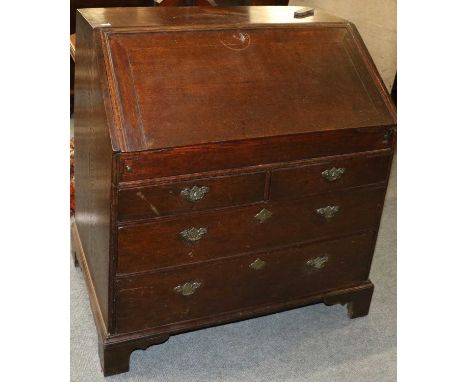 An Oak Bureau, 2nd quarter of the 18th century, the moulded fall enclosing a sliding well and an arrangement of small drawers