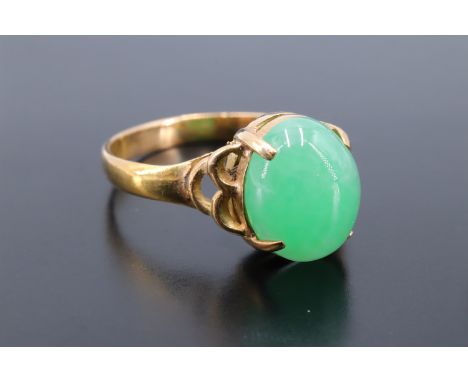 A jade cabochon ring, the oval stone claw-set on 18 K yellow metal, cabochon 10 mm x 8 mm, N/O. 2.9 g