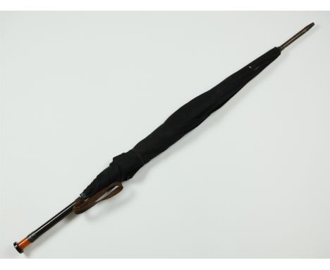A 1920s umbrella, having an Art Deco style amber and black Lucite or Bakelite pommel and engraved silver collar