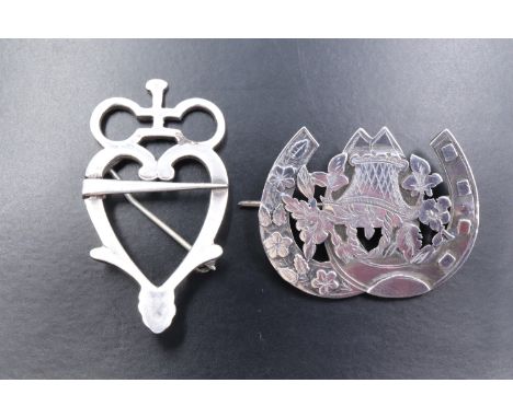 A vintage Scottish Luckenbooth influenced white metal brooch, together with a Victorian silver double-horseshoe brooch, latte