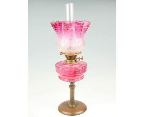 A late 19th Century copper and cranberry glass oil lamp with etched achromatising shade, with twin wick burners, 59 cm 