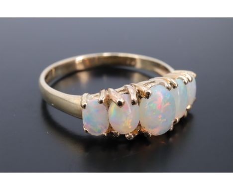 A five stone opal ring, comprising five graded oval cabochons, the central stone 7 mm x 5 mm, claw set on a 9 ct gold shank, 