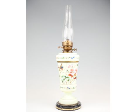 A Victorian hand painted milk glass oil lamp, depicting a song bird among flowers, with twin wick burner, 64 cm