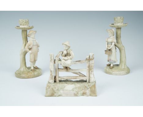 A Royal Worcester blush ivory figurine of a boy sat upon a gate, 1302, together with a pair of candle sticks, 938 and 939, ta