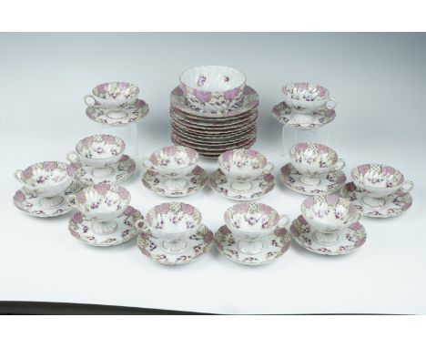 A late 19th/early 20th Century French Sevre influenced porcelain teaset, decorated in patterns of Rococo lattices, pink fish 