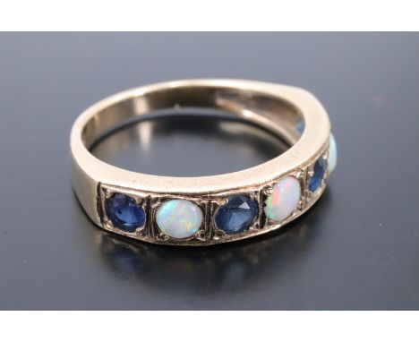 An opal and sapphire half hoop ring, comprising opal cabochons divided by round cut sapphires millegrain set in square cells 