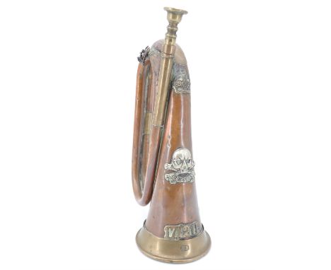 A copper and brass bugle bearing 17th/21st Lancers insignia