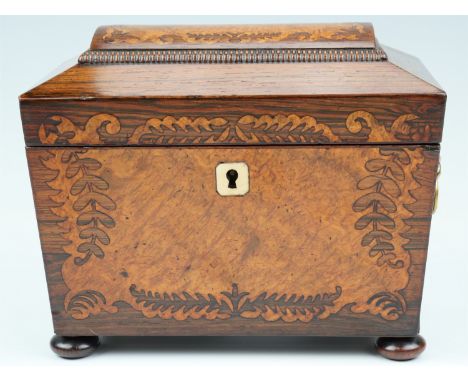 A 19th Century rosewood veneered two compartment tea caddy, of sarcophagus form having marquetry inlay, brass lion's mask han