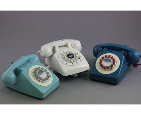 Three retro push button telephones in light blue, metallic blue and white