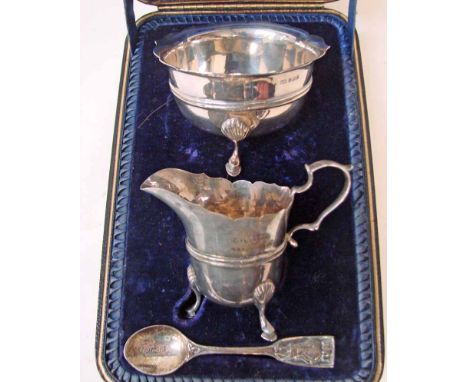 An Edwardian silver three-piece sugar and cream set consisting of a sugar bowl of circular form with shaped everted rim, ribb