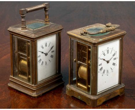 A French brass carriage clock, 14cm high with the handle down, together with a further brass carriage clock of smaller size, 