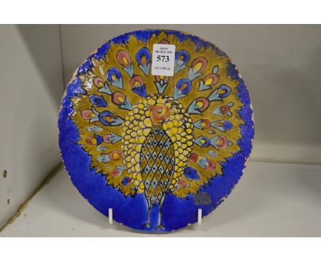 An Iznik style circular pottery tile painted with a peacock.