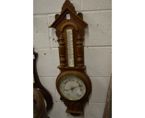 A Victorian barometer/thermometer with carved oak frame.