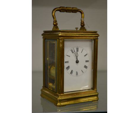 A brass carriage clock with repeat movement (dial cracked).