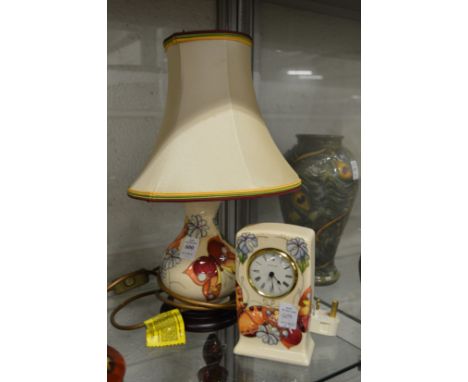 A modern Moorcroft table lamp decorated with butterflies and a matching desk clock.