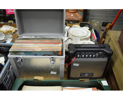An aluminium case containing LP records together with a mini amplifier.