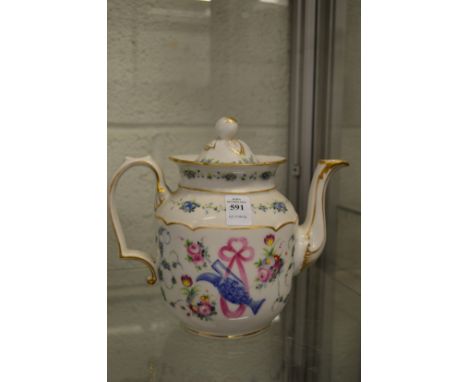 A porcelain teapot decorated with a ewer and ribbon amongst floral sprays.