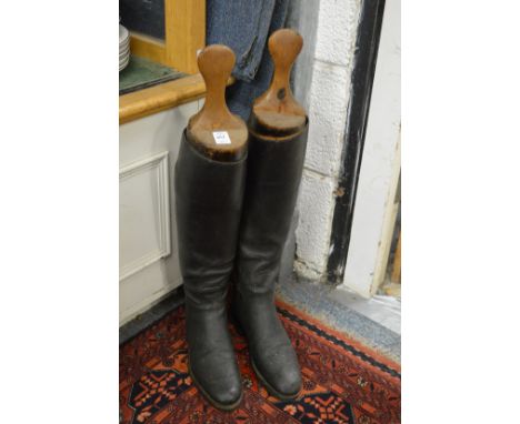 A pair of black leather hunting boots with wooden trees.