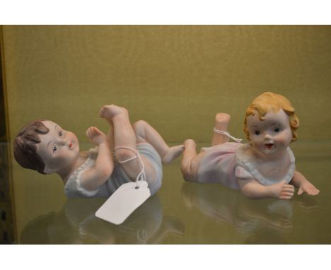 A pair of bisque porcelain babies.