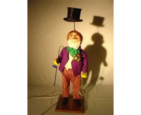The Man juggling Hat Wooden automaton, biscuit and fabric. It is presented standing holding an umbrella and a packet, his "to