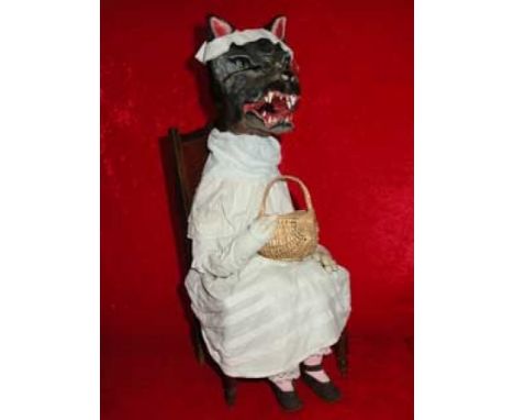 The Wolf in Grandma's outfit Wooden automaton, composition and fabric.Wolf disguised as grandmother sitting and holding a bas