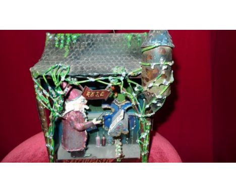 The Alchemist Mechanical toy depicting a small building inhabited by an alchemist and his tools. Manufactures plate at the ba