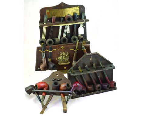 GROUP OF PIPE RACKS & STANDS. All wood some with brass decoration, sailing ship & SMOKE AND BE HAPPY. All with pipes. (4) NR