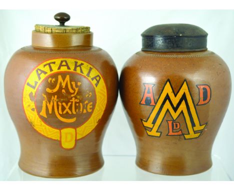 PAIR OF SHOP DISPLAY TOBACCO JARS. One 11ins tall to top of cork lid with brass finial, brown glaze LATAKIA/ MY MIXTURE in br