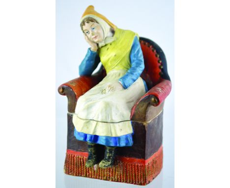 DUTCH GIRL TOBACCO JAR. 9ins tall, ceramic jar of girl sat in armchair in two halves in blue, white, yellow & orange colourin