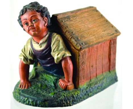 BOY IN KENNEL TOBACCO JAR. 6.75ins tall. Detailed ceramic of boy crawling out of kennel, kennel roof forms lid. Matt brown, g