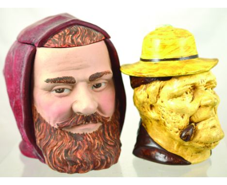 TWO TOBACCO JARS. Bearded mans head jar wearing red hood, matt red, brown & flesh coloured tones 6ins tall. Plus pipe smoking