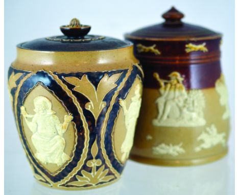 PAIR OF DOULTON TOBACCO JARS. One brown & tan salt glaze with raised hunting motifs all around in white. Doulton Lambeth p.m.