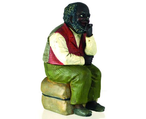 LARGE FIGURAL TOBACCO JAR. 8.25ins tall, continental tobacco jar formed as an elderly black man seated smoking a pipe in red,