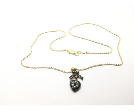 A yellow metal heart shaped pendant set with sapphire, pearl and a small diamond.