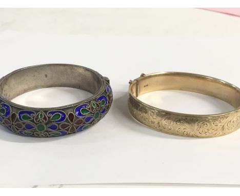 A 9ct gold cased bangle, contesting a fifth 9ct gold, and a silver and enamel bangle.